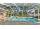 Pool with enclosed patio area and tropical backyard landscaping at 1455 Royal Forest Loop, Lakeland, FL 33811