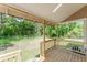 Cozy back porch with wooden deck and serene views of the surrounding green space, perfect for outdoor relaxation at 1480 Wauchula St, Intercession City, FL 33848