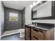 Bathroom showcasing a dark-tiled walk-in shower, modern vanity, and stylish fixtures at 1480 Wauchula St, Intercession City, FL 33848