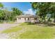 Charming front exterior with ample yard space and manicured landscaping, set against a backdrop of mature trees at 1480 Wauchula St, Intercession City, FL 33848