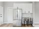 Updated kitchen with stainless steel refrigerator, white cabinetry, and counter seating at 1480 Wauchula St, Intercession City, FL 33848
