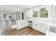 Open-concept kitchen with white cabinets, countertops, stainless steel appliances, and sleek flooring at 1480 Wauchula St, Intercession City, FL 33848