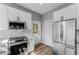 Modern kitchen boasts white cabinets, stainless steel appliances, and stylish wood-look flooring at 1480 Wauchula St, Intercession City, FL 33848