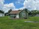 Charming green home featuring a small front porch and a lush green lawn at 1519 Illinois Ave, St Cloud, FL 34769
