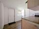 View of an unfinished kitchen area with wood-look floors, a small window, and white doors at 1519 Illinois Ave, St Cloud, FL 34769