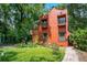 Charming two-story red home featuring a yellow door, two balconies, and lush landscaping at 1600 Dauphin Ln, Orlando, FL 32803
