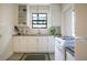 Well-lit kitchen with white cabinetry, subway tile backsplash and stainless steel sink beneath a window at 1600 Dauphin Ln, Orlando, FL 32803