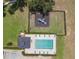 Aerial view of the pool and playground in this community, surrounded by lush greenery and featuring lounge chairs at 16243 Wilkinson Dr, Clermont, FL 34714