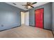 Bedroom featuring gray walls, red door, and beige carpet at 16243 Wilkinson Dr, Clermont, FL 34714