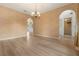 Spacious dining room with wood-look floors, neutral walls and arches that lead into other spaces at 16243 Wilkinson Dr, Clermont, FL 34714