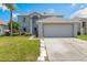 Charming two-story home with a well-manicured lawn and a two car garage on a sunny day at 16243 Wilkinson Dr, Clermont, FL 34714