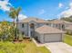 Two-story home with a two-car garage, and a well-manicured lawn at 16243 Wilkinson Dr, Clermont, FL 34714