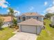 Two-story home with a two-car garage, and a well-manicured lawn at 16243 Wilkinson Dr, Clermont, FL 34714