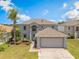 Two-story home with a two-car garage, and a well-manicured lawn at 16243 Wilkinson Dr, Clermont, FL 34714