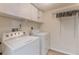 Laundry room featuring a washer, dryer, cabinets, and hanging rack at 16243 Wilkinson Dr, Clermont, FL 34714