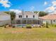 Home's rear exterior with screened pool, spa, and grassy backyard at 16243 Wilkinson Dr, Clermont, FL 34714
