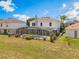 Home's rear exterior with screened pool, spa, and grassy backyard at 16243 Wilkinson Dr, Clermont, FL 34714