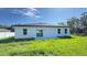 Home's backyard featuring a newly installed lawn, large windows, and a sliding glass door at 16252 Sw 27Th Terrace Rd, Ocala, FL 34473