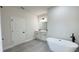 Bathroom with double vanity, modern lighting, a free-standing tub, and neutral-colored tile floor at 16252 Sw 27Th Terrace Rd, Ocala, FL 34473