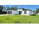A modern single-Gathering home with a white exterior, gray accents, and a well-manicured lawn at 16252 Sw 27Th Terrace Rd, Ocala, FL 34473