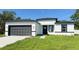 A bright single-Gathering home featuring a gray garage door and minimalist modern design at 16252 Sw 27Th Terrace Rd, Ocala, FL 34473