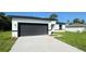 A single-Gathering home showcasing a spacious driveway and a contemporary gray garage door at 16252 Sw 27Th Terrace Rd, Ocala, FL 34473