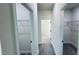 Hallway with neutral paint, wood-look floors, and two storage closets for optimal home organization at 16252 Sw 27Th Terrace Rd, Ocala, FL 34473