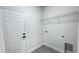 A functional laundry room with a metal shelf and door access at 16252 Sw 27Th Terrace Rd, Ocala, FL 34473