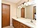 Bathroom with a double sink vanity, large mirror, and wood door at 173 Tollgate Br, Longwood, FL 32750