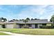 Charming single-story home with stone accents, a gray roof, green lawn, and a sidewalk to the front door at 173 Tollgate Br, Longwood, FL 32750
