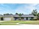 Charming single-story home with stone accents, a gray roof, green lawn, and a sidewalk to the front door at 173 Tollgate Br, Longwood, FL 32750