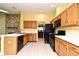 Spacious kitchen with white counters, wooden cabinetry, and black appliances at 173 Tollgate Br, Longwood, FL 32750
