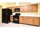 Kitchen featuring oak cabinetry, black appliances and light countertops at 173 Tollgate Br, Longwood, FL 32750