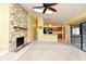 Bright living room featuring a stone fireplace, ceiling fan, and sliding glass doors to the lanai at 173 Tollgate Br, Longwood, FL 32750