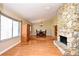 Open floor plan with hardwood floors, a stone fireplace, and a view into the dining area, perfect for entertaining guests at 173 Tollgate Br, Longwood, FL 32750