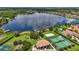 Aerial view of a serene lake community featuring tennis courts, a playground, and lush green spaces for outdoor activities at 1813 Glenbay Ct, Windermere, FL 34786