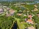 Aerial view of a neighborhood with mature trees, ponds, and green space, and features homes with terracotta tile roofs at 1813 Glenbay Ct, Windermere, FL 34786