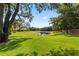 Expansive green backyard featuring a serene pond surrounded by mature trees, and a well-manicured lawn at 1813 Glenbay Ct, Windermere, FL 34786