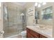 Bathroom featuring a tiled shower with glass door, a wood vanity, and floating shelves for plants at 1813 Glenbay Ct, Windermere, FL 34786