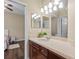 Bathroom with wood vanity, a large mirror, and a view into an adjacent bedroom at 1813 Glenbay Ct, Windermere, FL 34786