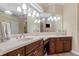 Bright bathroom boasts double sinks, dark wood cabinetry, and a large mirror with Hollywood-style lighting at 1813 Glenbay Ct, Windermere, FL 34786