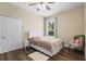 Bedroom with wood floors, a queen bed with a white headboard, and a window view at 1813 Glenbay Ct, Windermere, FL 34786