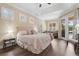 Inviting bedroom with hardwood floors, a tray ceiling, plantation shutters, and an outdoor view at 1813 Glenbay Ct, Windermere, FL 34786