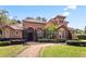 Stunning Mediterranean-style home with a red tile roof, arched entryway, and lush, mature landscaping at 1813 Glenbay Ct, Windermere, FL 34786