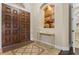 Elegant entryway featuring a dark wood double door, decorative niche, stylish table, and tile flooring at 1813 Glenbay Ct, Windermere, FL 34786