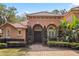 Home exterior featuring a tile roof, brick path, arched entryway, and green landscaping at 1813 Glenbay Ct, Windermere, FL 34786