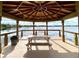 Interior of a wooden gazebo overlooking a serene lake, with a picnic table for residents at 1813 Glenbay Ct, Windermere, FL 34786