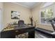 Bright home office with a modern desk, exercise equipment and plantation shutters at 1813 Glenbay Ct, Windermere, FL 34786