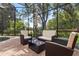 This outdoor seating area has comfortable wicker furniture and a glass table, set within a screened-in patio at 1813 Glenbay Ct, Windermere, FL 34786