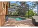 A screened-in pool features a stone waterfall and a surrounding brick patio with a bar, perfect for outdoor living at 1813 Glenbay Ct, Windermere, FL 34786